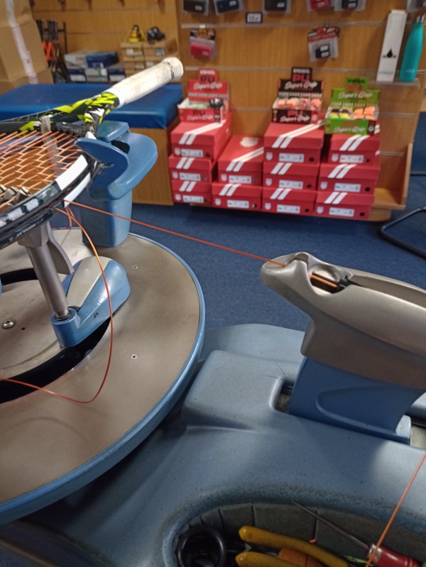 String being tensioned during racket stringing process